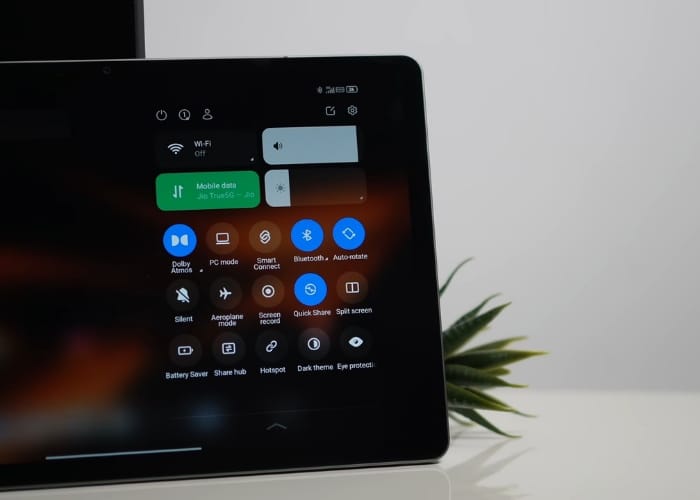 Moto Pad 60 Neo next to keyboard and headphones in a productivity setup