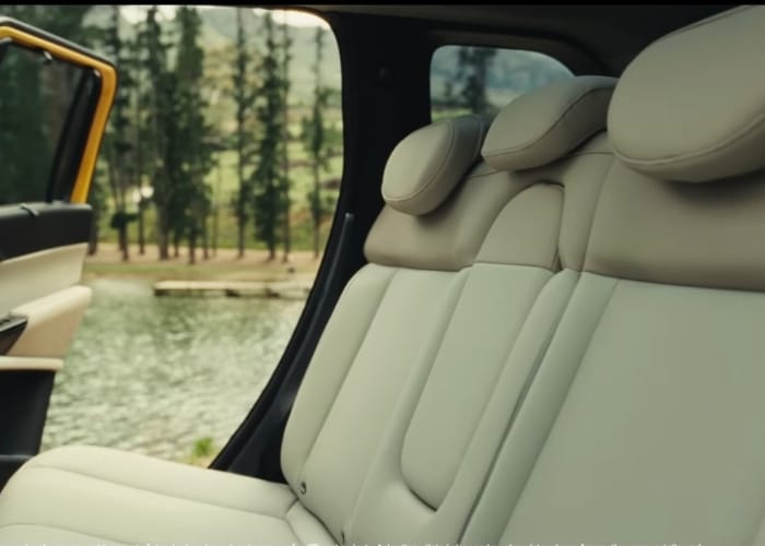 Side profile of Tata Sierra SUV driving on road showcasing alloy wheels